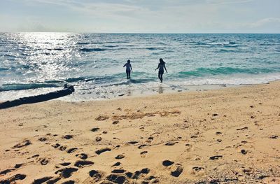 People on beach against sky