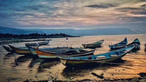 Boats moored in sea against sky