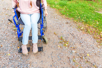 Low section of woman standing on footpath