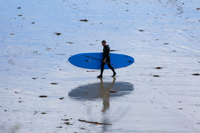 High angle view of man with surfboard on beach