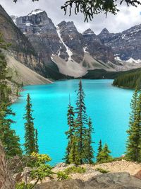 Brilliant turquoise waters of lake by snow capped mountain peaks