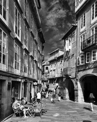 People on street in city against sky