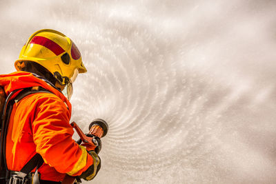 Firefighter spraying water through fire hose