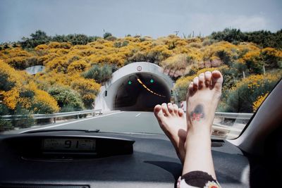 Low section of woman against windshield in car