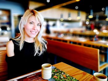 Portrait of a smiling young woman at restaurant