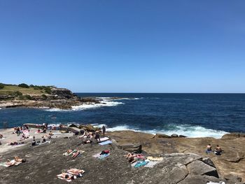 People on beach against clear sky