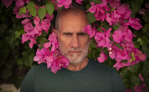 Portrait of adult man with pink flowers
