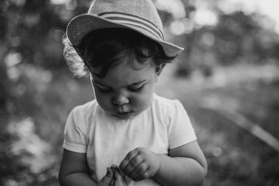 Cute baby girl wearing hat standing outdoors