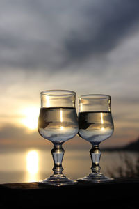 Reflection of sunset on water in drinking glasses