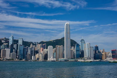 City at waterfront against cloudy sky