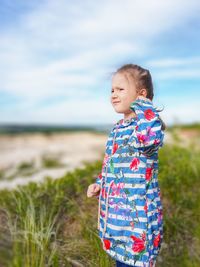 Young girl looking ahead against the sky