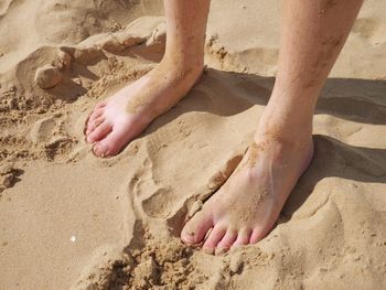 Close-up of feet in sand