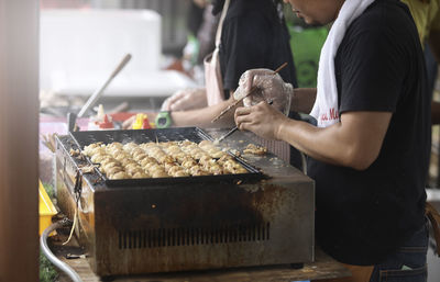 Midsection of man preparing food