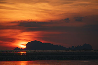 Scenic view of sea against dramatic sky during sunset