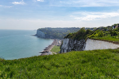 Scenic view of cliff by sea against sky