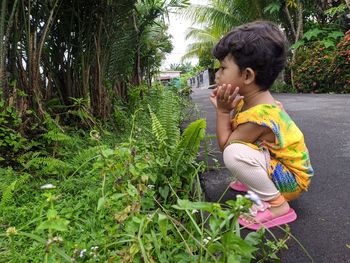 Side view of boy on plants