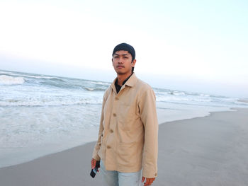 Young man standing on beach