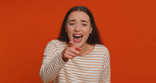 Portrait of young woman against yellow background