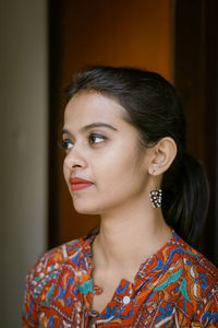 Close-up of thoughtful woman standing at home