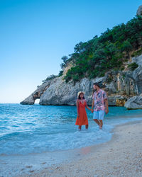 Rear view of woman standing at beach