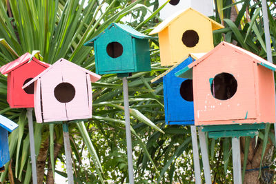 Multi colored birdhouses against plants