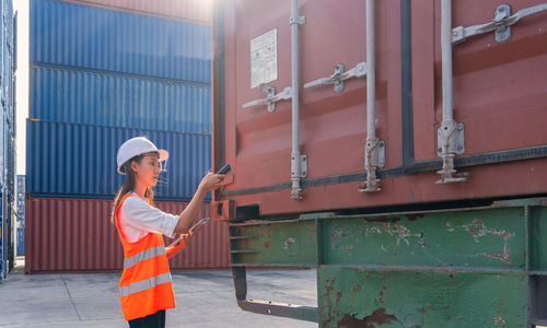 Engineers are overseeing the transportation of cargo with containers inside the warehouse.