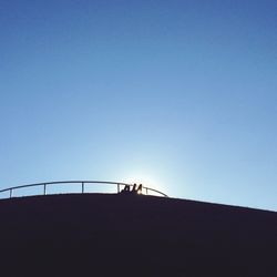 Low angle view of silhouette trees against blue sky