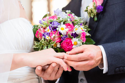 Midsection of man holding rose bouquet