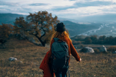 Rear view of woman walking on field