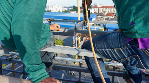 Welding of metal structures on extension of a building. sparks and smoke fly as steel is welded.