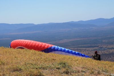 Scenic view of field against sky and parachute 