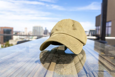 Rear view of person wearing hat against sky in city