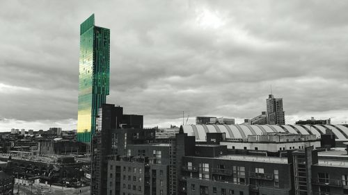 Buildings in city against cloudy sky