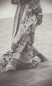 Low section of woman sitting on the beach