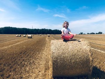 Girl meditating on hay bale