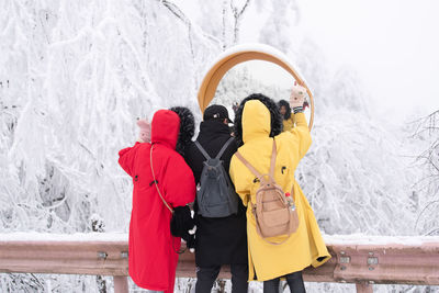 Rear view of woman with umbrella during winter