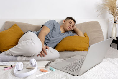 Young man is very tired after studying and fell asleep. man with casual clothes lying on the bed 