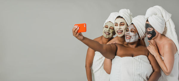 Rear view of woman holding gift against white background