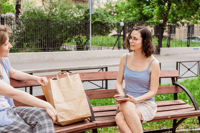 Woman sitting on bench in park