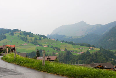 Scenic view of landscape and houses against sky