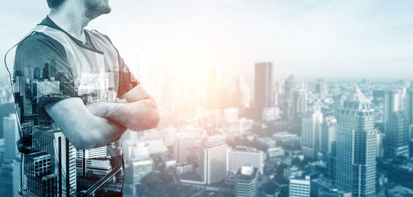 Digital composite image of man and cityscape against sky