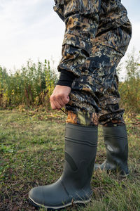 Low section of man standing on field