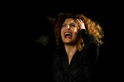 Portrait of teenage girl against black background