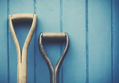 Close-up of shovel against wooden wall