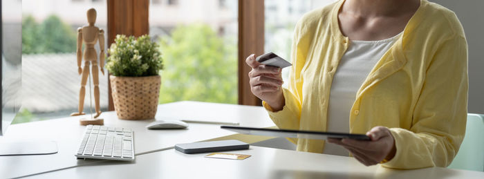 Midsection of woman working on table