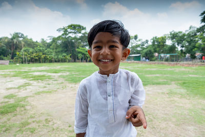 Portrait of smiling boy standing on field