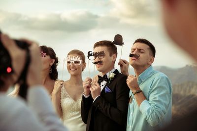 Portrait of smiling young couple against sky