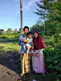 Portrait of friends standing against plants