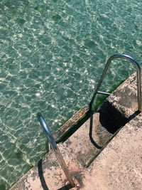 High angle view of ladder by swimming pool