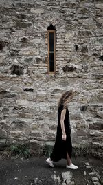 Full length of woman on window of abandoned building